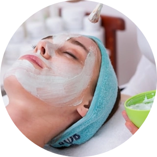 Gözəllik salonunda peşəkar tərəfindən üz maskası tətbiq edilərkən dincələn qadın.