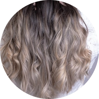 Qaranlıq saçlarda təbii görünüşlü, üçölçülü dalğalar və problemsiz, az qulluq tələb edən kök xətti ilə diqqət çəkən heyranedici kül-sarı balayaj.